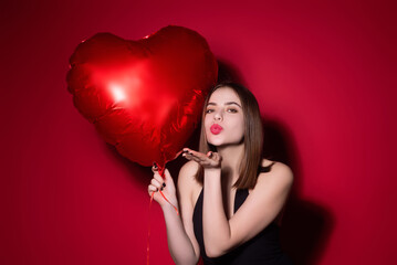 Woman in love with heart. Beautiful young woman holding red heart baloons, valentines day. Romance...