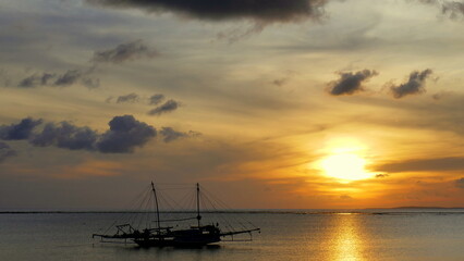 Herrlich warmer Sonnenuntergang mit großem Fischerbootbei Nembrala in Westtimor auf der Insel Rote...