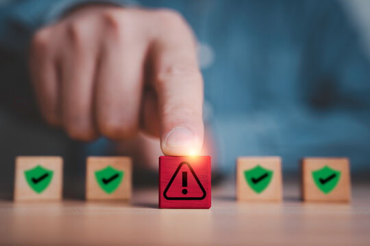 Hand phishing red exclamation waring caution sign symbol in front of safety icon for notification error and maintenance concept.