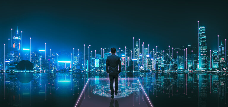 Professional business man on future technology city at night in Victoria Harbour Hong Kong