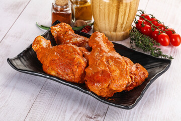 Raw turkey shoulder wing in Indian tandoori marinade