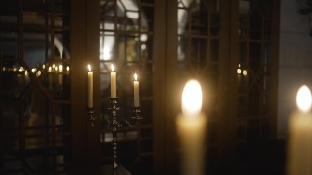 Restaurant interior with candlesticks and lit candles. Catholic church inside, lit candles. Lit candles in a cozy restaurant.
