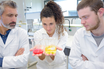 scientific researcher holding at a liquid solution in a lab