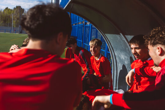 Happy soccer team talking with each other son sunny day