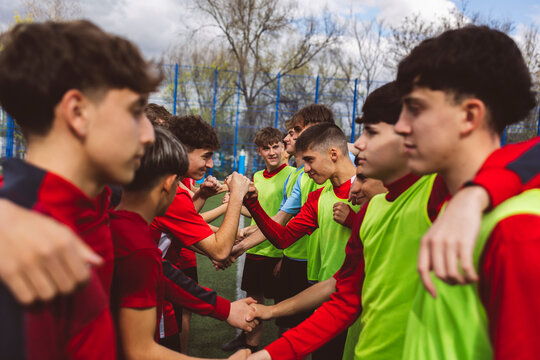 Soccer players shaking hands together on field
