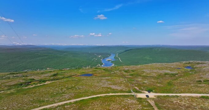 Aerial view over a fell, revealing the Sami Bridge and Teno river, in Utsjoki, Finland
