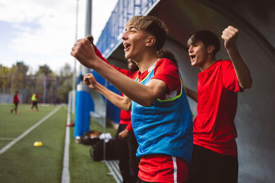Cheerful soccer players celebrating victory on field