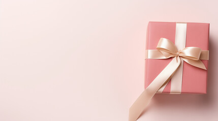 A pink gift box tied with a satin ribbon awaits to be opened, adding a touch of elegance to the celebration, copy space