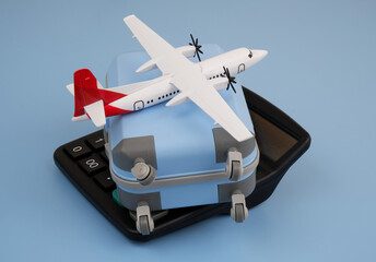 Airplane tickets cost and travel budget concept. Airplane and travel suitcase on calculator on blue background.