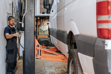 Auto expert working on vehicle maintenance inside garage