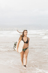 Surfer with surfboard walking on sea beach