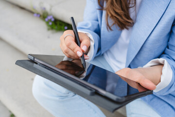 Hand of businesswoman using digitized pen on tablet PC