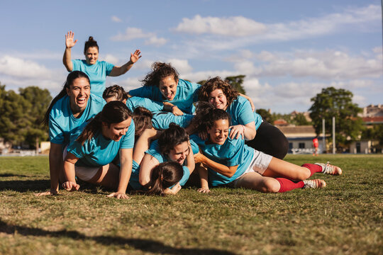 Happy rugby players in scrum on field - Powered by Adobe