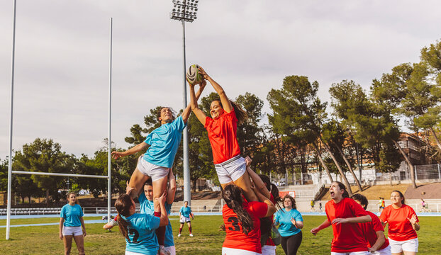 Rugby lineout jumper supported by team at field