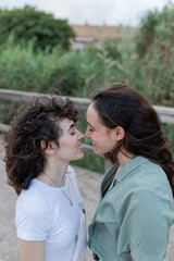 Fototapeta premium Lesbian couple interacting on bridge in daytime