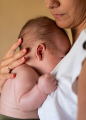 Loving mother hugging newborn at home