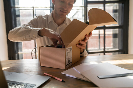 Businessman unboxing package at desk