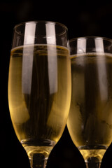 Vertical close-up of elegant champagne glasses filled with sparkling champagne. Captures the essence of celebration and holiday cheer for New Year's Eve and Christmas.