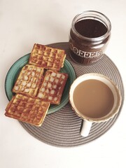 Coffee and waffles on a plate on a white background