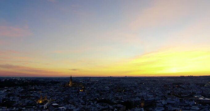 Drone footage of a sunset in Seville where you can see the Cathedral and the rooftops of the city under the orange colours.
