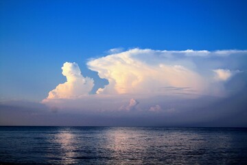 Clear sky with glowing cumulus clouds above the Black sea after wake up cloud hanging over water after the storm