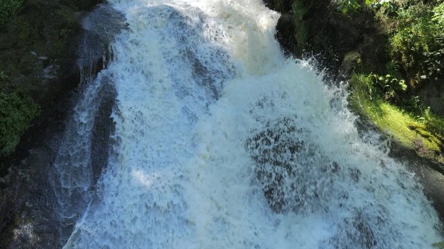 The highest waterfall of the Black Forest in Triberg, Germany. Slow motion of falling clear mountain water in detail. Big rocky stones covered with green moss in a mountain place