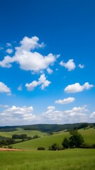 Obraz premium Peaceful Countryside Under Expansive Blue Sky with Serene White Clouds