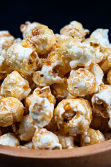 vertical close up shot of pile of popcorn in wooden bowl
