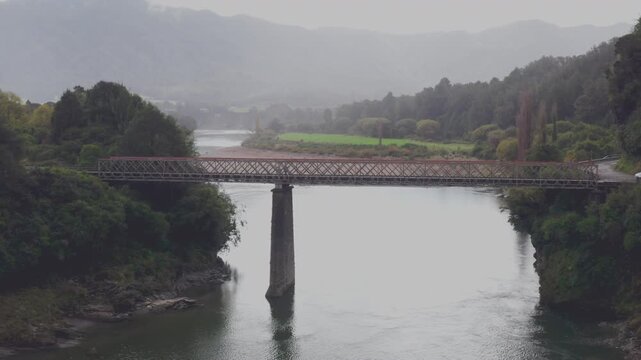 Aerial drone shot of vehicles crossing the Iron Bridge over the Buller River in New Zealands south island