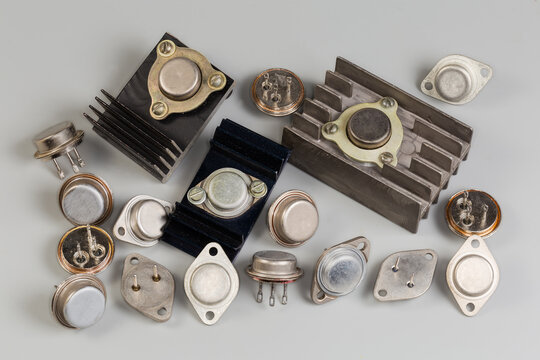 Different old power transistors in metal packages on gray surface