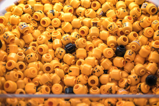 Pile of LEGO minifigure head studs with various facial expressions in the LEGO store Leicester Square, London