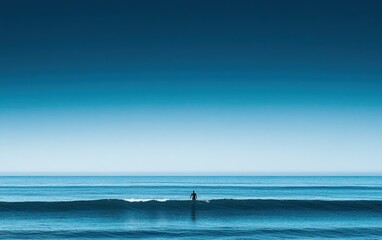 Silhouette of Surfer Standing on a Wave in the Ocean with a Clear Blue Sky