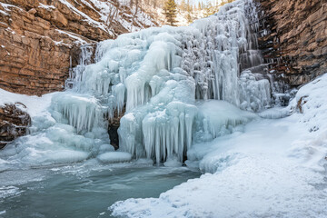 Obraz premium A Frozen Waterfall Capturing Nature's Icy Majesty and the Serene Beauty of Winter's Chilling Embrace in a Quiet Landscape.