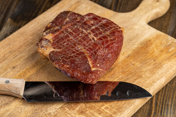 a piece of cured pork ham with thin layers of lard on the table