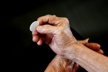 Old People Hand holding bread in a Holy communion.