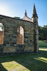 Light shines through the remains of an old church built by convicts of a famous Tasmanian prison. Port Arthur Heritage Site. Historic buildings and museums in Tasmania. The Convict Church, Port Arthur