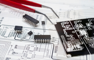 Electronic components and tools on an engineering blueprint for circuit board design.