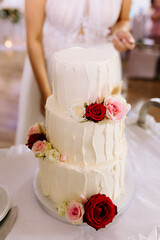 Para młoda kroi tory na weselu stół z tortem na sali pan młody i pani młoda moment torcik kremowy z kwiatami dekoracje ślubne © jusiamastalerz