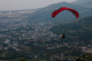 Some people are paragliding on a mountain with beautiful views