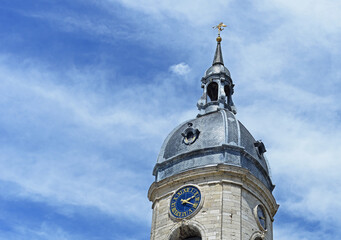 Bell tower of belfry in Amiens with clock, blue sky with white clouds, France