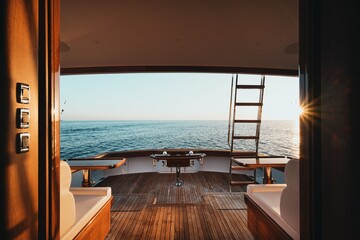 Fototapeta premium Luxurious yacht deck with wooden floor and ocean view at sunset
