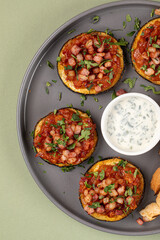Eggplant appetizer with tomatoes and toast on green background