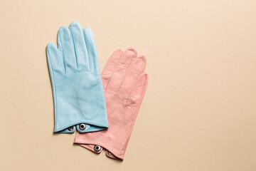 A creative multi-colored pair of gloves on a beige background