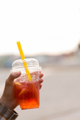 A plastic cup with bubble tea is in the woman's hand