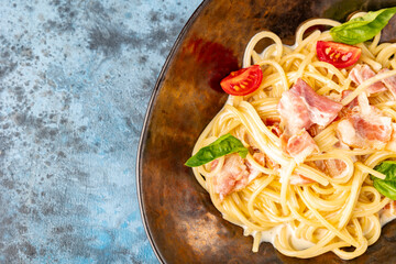 Classic pasta Carbonara in a ceramic plate, hearty Italian dish made with Spaghetti, egg, fried...