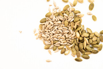 A mixture of pumpkin seeds (pepitas), which are flat and greenish, and sunflower seeds, which are...