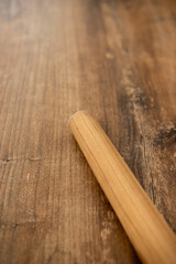a wooden rolling pin for dough lies on the table