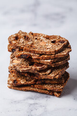 Healthy nuts and seed bread on white marble background.