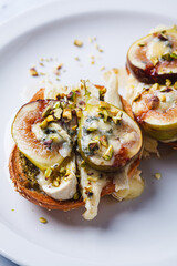 Toasts with pesto, brie, dorblu, fig and pistachio.