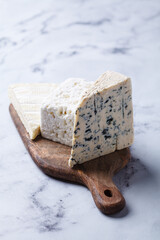 Assortment of cheeses on wooden board.